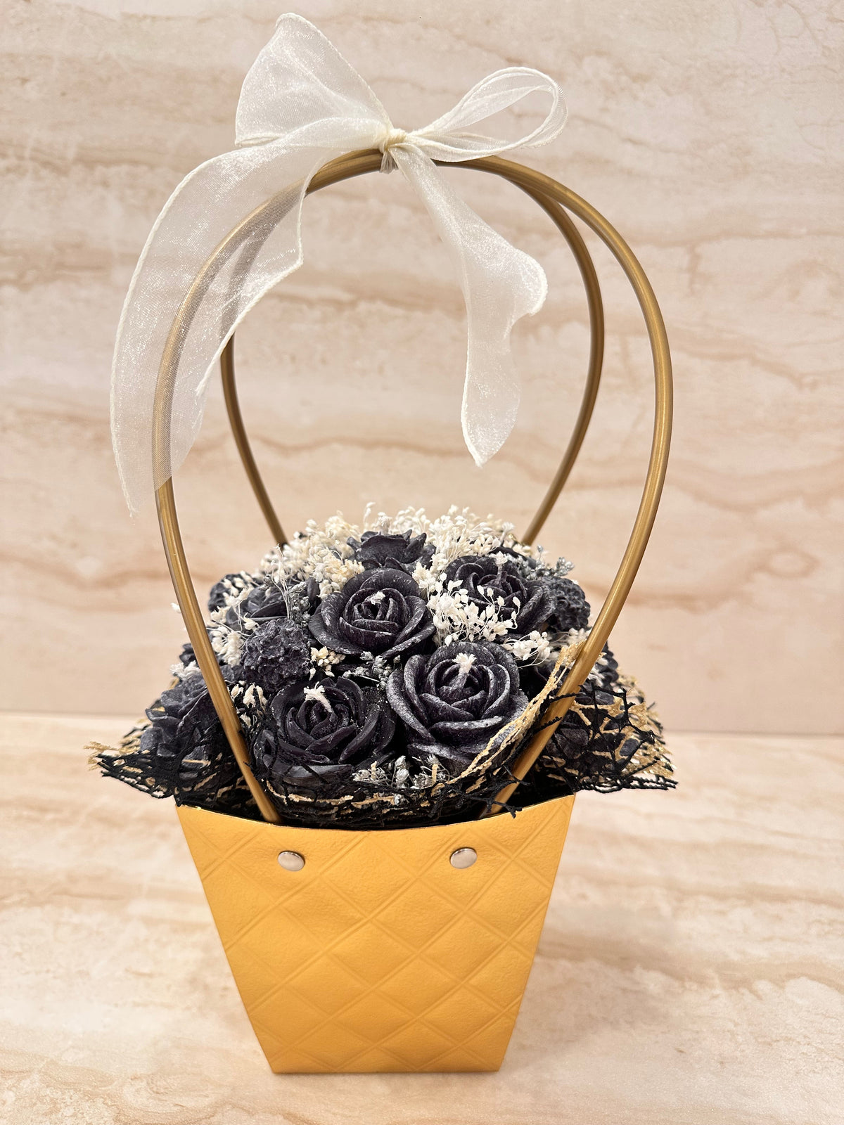 Flower Box Pure Vibe w złotej torebce z czarnymi kwiatami z wosku i białą kokardą – widok z przodu