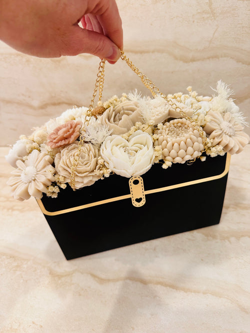 Bezzapachowy Flower Box w czarnej torebce ze złotym łańcuszkiem i kwiatami z wosku – widok z przodu