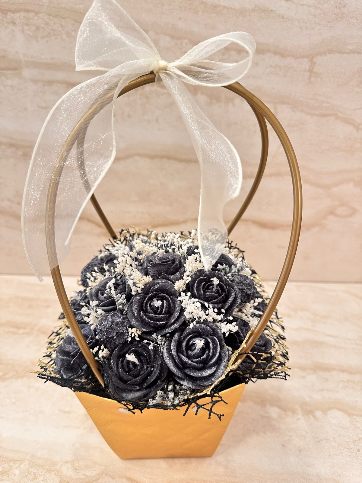 Złota torebka z Flower Boxem Pure Vibe i czarnymi kwiatami z wosku – widok z przodu