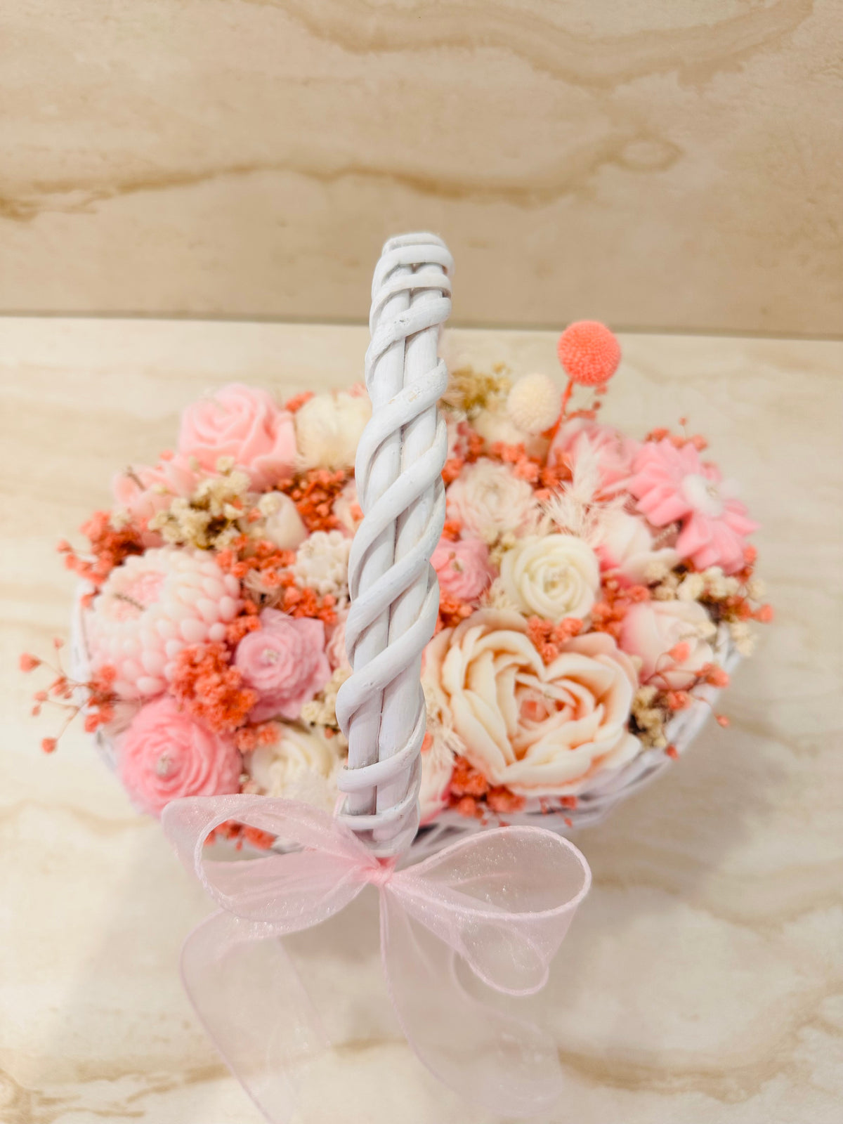 Biały koszyczek wiklinowy Flower Box z różową kokardą i kwiatami z wosku – widok z boku