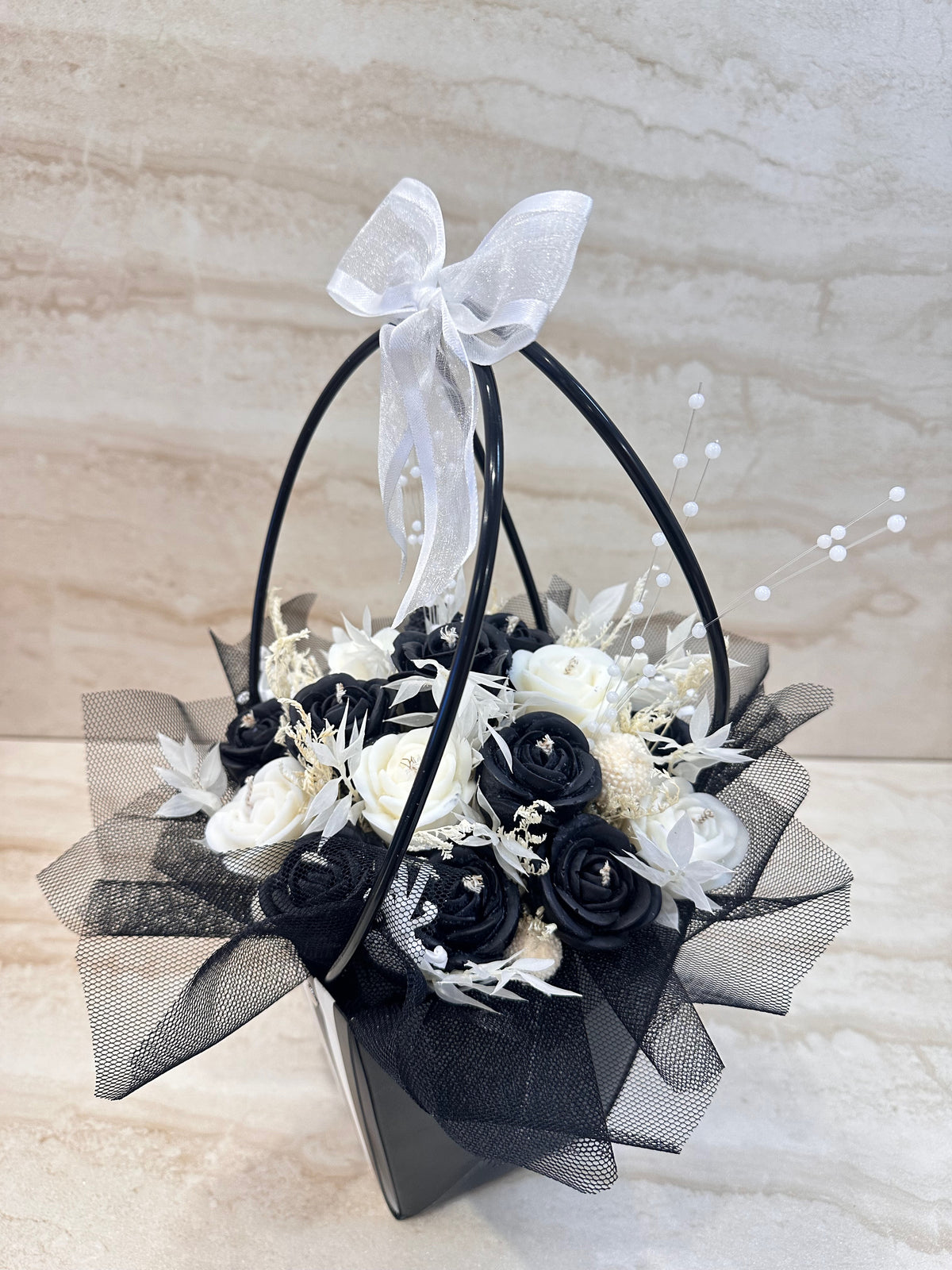Flower Box z czarnymi i białymi kwiatami z wosku w torebce prezentowej – widok z boku