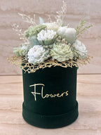 Zielony Flower Box Pure Vibe w ciemnozielonym welurowym pudełku z białymi i miętowymi kwiatami z wosku – widok z przodu