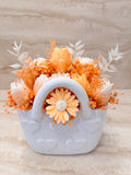 Flower Box Pure Vibe w białej ceramicznej torebce z kwiatami z wosku w odcieniach brzoskwini i bieli – widok z przodu