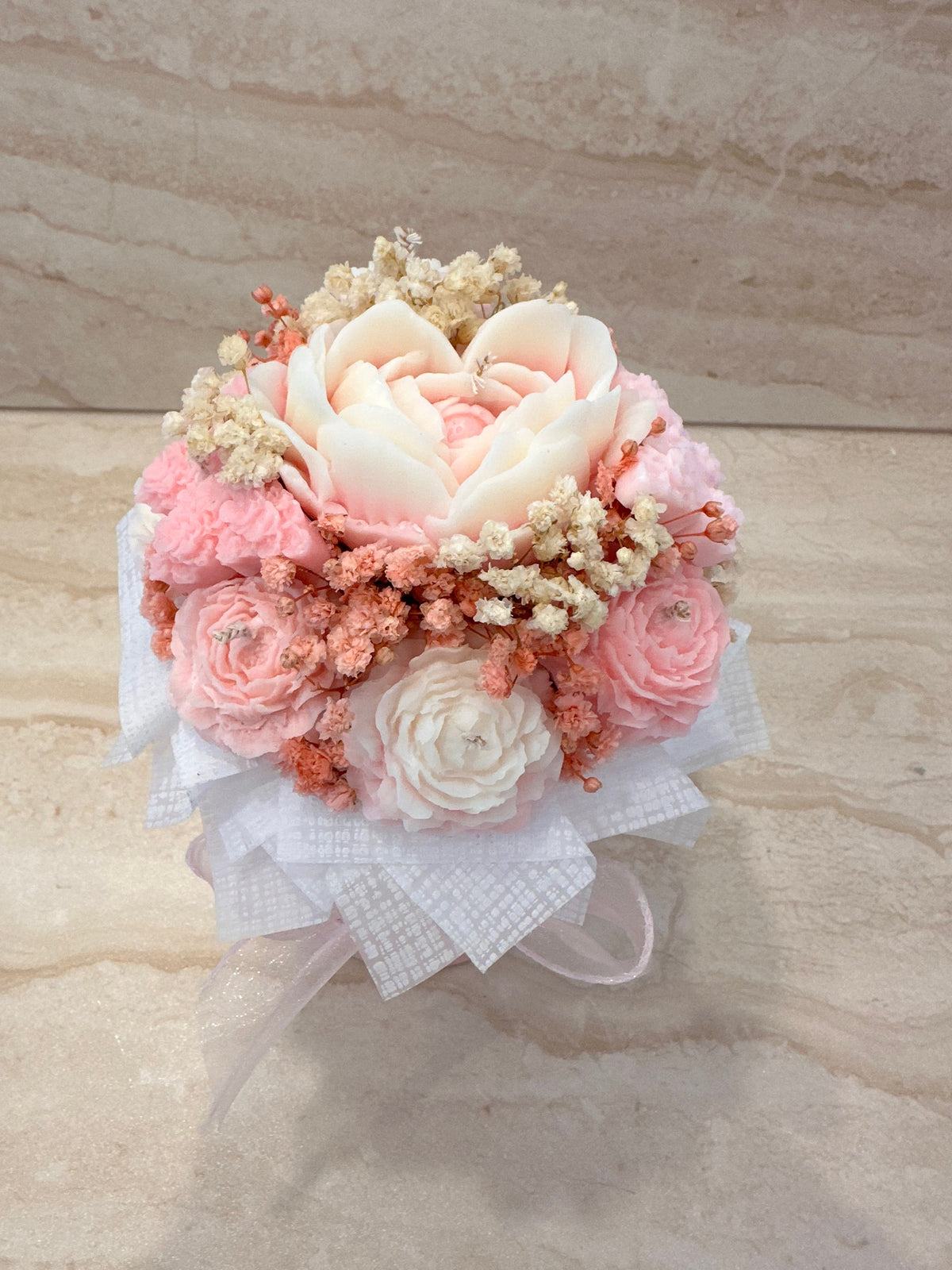 Różowy Flower Box z kwiatów z wosku w okrągłym pudełku, ozdobiony jasnoróżową kokardą – widok z góry